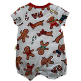 A baby short-sleeve romper in light gray with a festive Christmas print featuring gingerbread men, dachshunds, candy canes, and red 'PA' lettering, laid flat on a speckled beige countertop.
